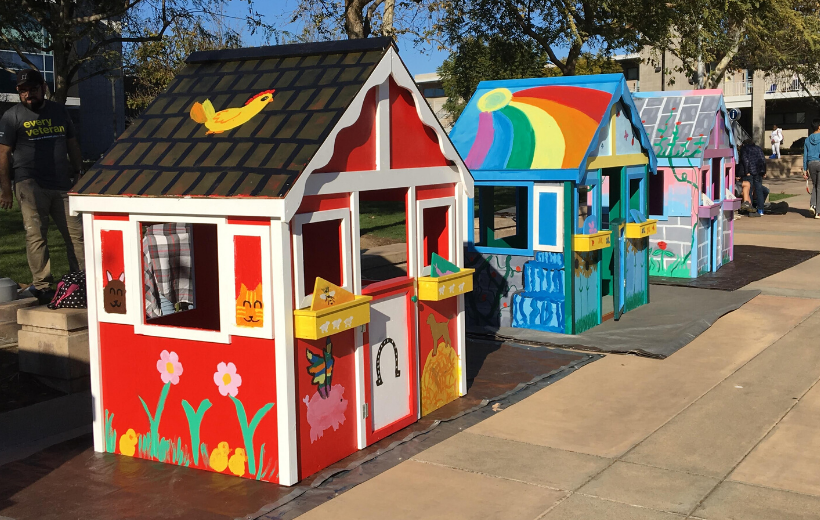 Three colorful playhouses assembled and decorated by Habitat volunteers