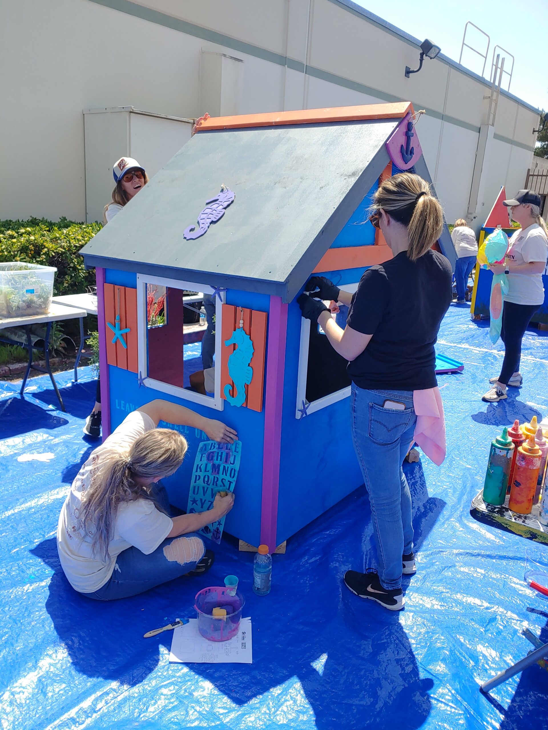 Two women building a playhouse at a women build event